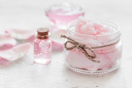 spa set with rose flowers extract and cosmetic for body on white desk backgroundの写真素材