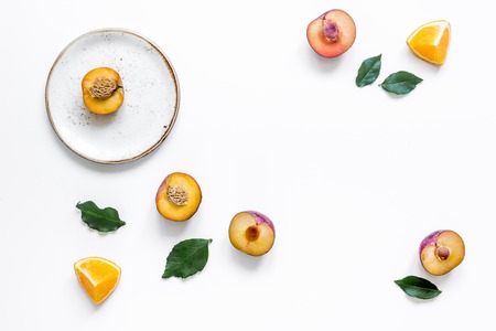 tropical peach and orange fruits for fresh summer juice on plates on white table background top view space for textの写真素材