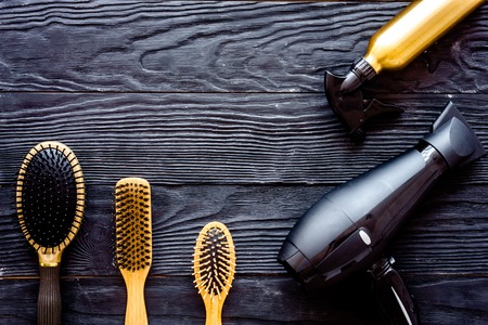 Brushes, hairdryer and hairspray on grey wooden background top view.の写真素材