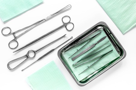 Surgical instruments and tools including scalpels, forceps and tweezers on white table top viewの写真素材