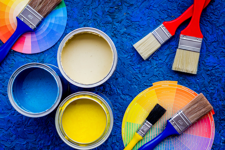 Colorful paints and brushes on blue wooden desk background top viewの写真素材