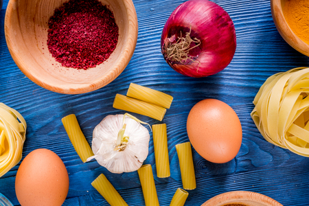 Food ingredients for Italian pasta on blue wooden desk background top view close upの写真素材