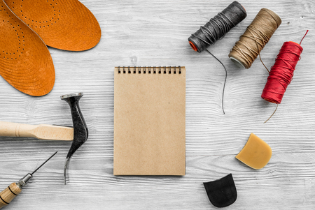 Cobbler takes order. Notebok on grey wooden desk background top view mockupの写真素材