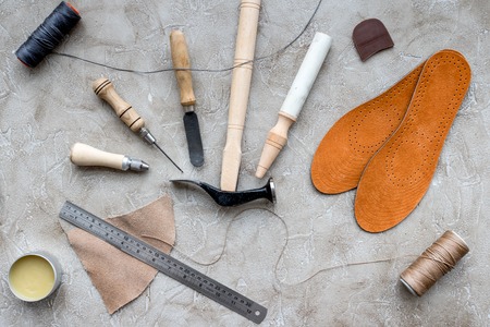 Set of cobbler tools on grey stone desk background top viewの写真素材