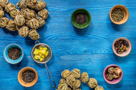 herbs in colorful bowls to make tea on blue table background top viewの写真素材