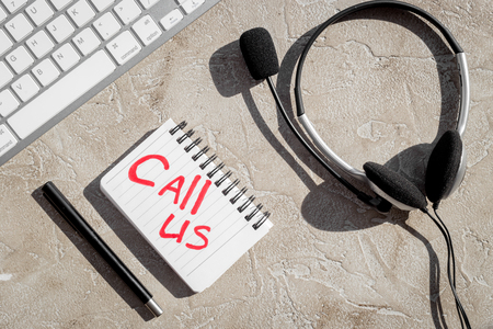 customer support service desktop with contact us copy stone background top viewの写真素材