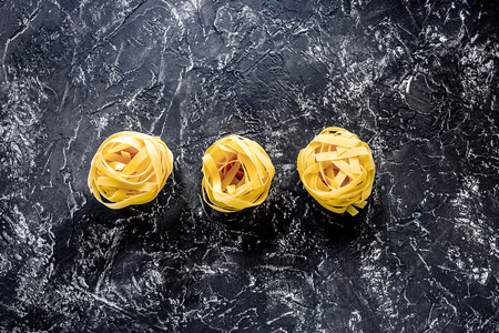Italian pasta fettuccine nest on grey stone table top view copyspaceの写真素材