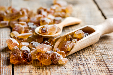 lumps of white and brown sugar on wooden kitchen table backgroundの写真素材