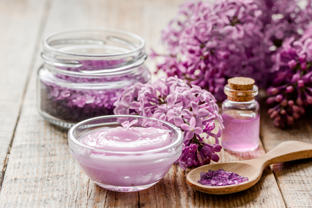 lilac natural cosmetic set for spa with salt wooden table backgroundの写真素材