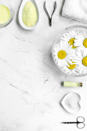 Spa composition on white desk with salt, chamomile, towel and manicure set copyspase top view verticalの写真素材