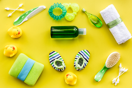 Baby care with bath cosmetic set, ducklings and towel on yellow background top view patternの写真素材