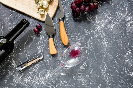 Bottle of red wine with cheese and grape aperitive on grey stone table background copyspace top viewの写真素材