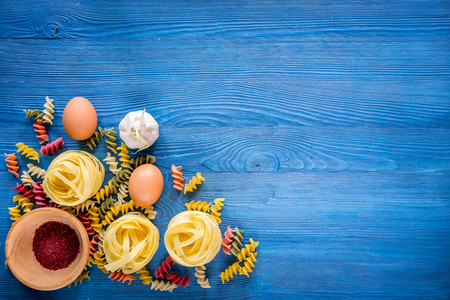 Food ingredients for Italian pasta on blue wooden desk background top view copyspace.の写真素材