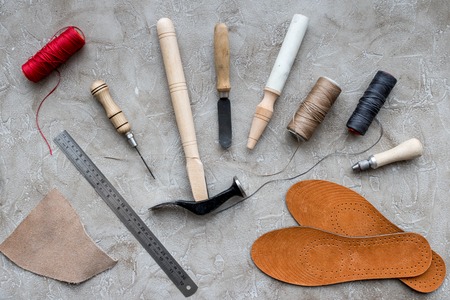 Set of cobbler tools on grey stone desk background top viewの写真素材