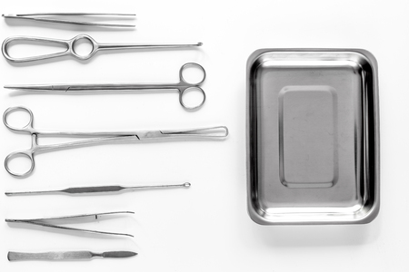 Surgical instruments and tools including scalpels, forceps and tweezers on white table top view mock upの写真素材