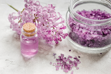spa cosmetic set with lilac flowers stone desk backgroundの写真素材