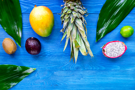 Exotic fruit meal. Dragonfruit, mangosteen, mango, kiwi, lime and pineapple on blue wooden background top view copyspaceの写真素材