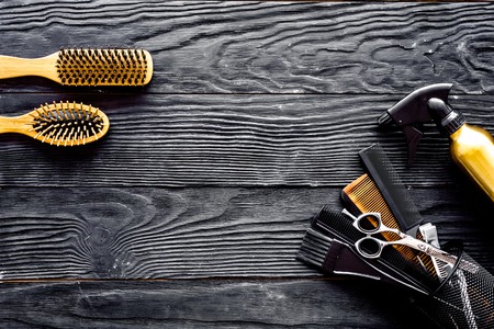 Brushes, hairdryer and hairspray on grey wooden background top view space for textの写真素材
