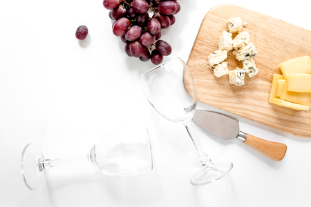 Bottle of red wine and wine glasses with cheese and grape aperitive on white background copyspace top viewの写真素材