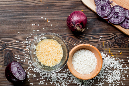 paella ingredients with rice, salt, spices and tomatoes on wooden kitchen table background top viewの写真素材