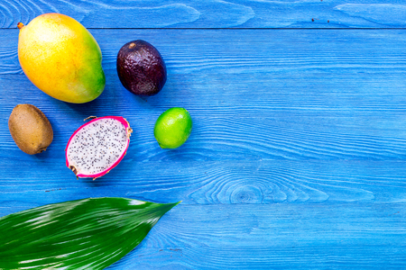 Exotic fruits dragonfruit, mangosteen, mango, kiwi and lime on blue wooden table background top view copyspaceの写真素材