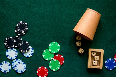 Poker chips and dices on a green gaming table top view copyspace close upの写真素材