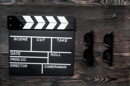 Attributes of film director. Movie clapperboard and sunglasses on wooden table background top viewの写真素材