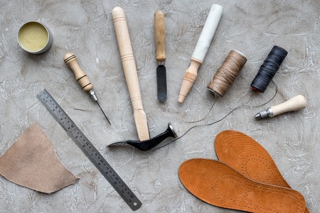 Set of cobbler tools on grey stone desk background top viewの写真素材