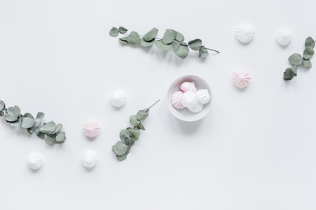 woman lunch with marsh-mallow in plate and flowers soft light on white table background flat layの写真素材
