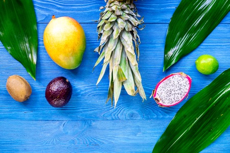 Exotic fruit meal. Dragonfruit, mangosteen, mango, kiwi, lime and pineapple on blue wooden background top view copyspaceの写真素材