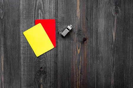 Yellow and red referee cards and whistle on wooden background top view copyspaceの写真素材