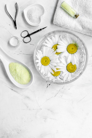 natural cosmetics with bowl of chamomiles and tools for manicure on white textural background top view space for text.の写真素材
