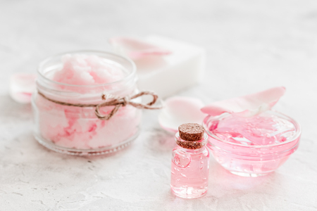 Cosmetic set with rose blossom and body cream for treatment on white desk backgroundの写真素材