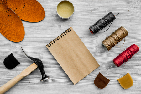 Cobbler takes order. Notebok on grey wooden desk background top view mockup.の写真素材