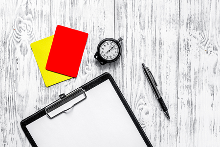 Football refereeing. Yellow and red referee cards, stopwatch, pad, on wooden background top view.の写真素材