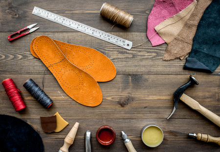 Set of cobbler tools on brown wooden desk background top viewの写真素材