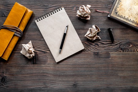 Writer concept. Pen, vintage notebook and crumpled paper on wooden table background top view.の写真素材