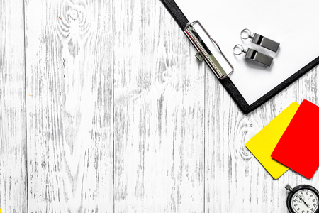 Referee preparing to competition. Yellow and red cards, stopwatch, whistle on wooden background top view.の写真素材