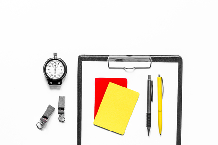 Set to judge competition. Yellow and red cards, stopwatch, whistle, pad on wooden background top view.の写真素材