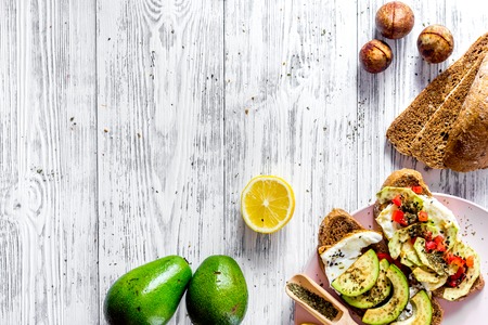 Vegetarian breakfast. Sandwiches with avocado, fried eggs and paprika on wooden table background top view copyspaceの写真素材