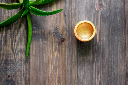 Organic aloe vera cosmetics. Aloe vera leafs and spa lotion on wooden table background top view copyspace.の写真素材