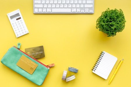 Online shopping. Bank card in purse nearby keyboard on yellow background top view.の写真素材