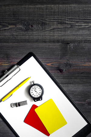 Yellow and red referee cards and whistle on wooden background top view.の写真素材
