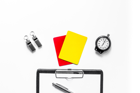 Set to judge competition. Yellow and red cards, stopwatch, whistle, pad on wooden background top view.の写真素材