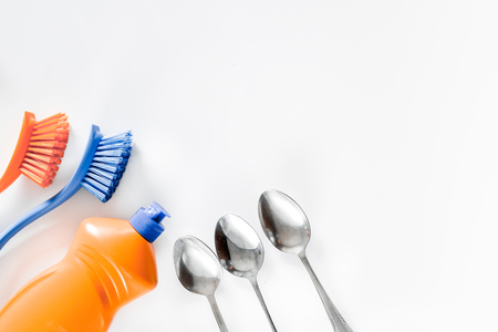 Dishwashing liquid, brushes and tableware on white background top view.の写真素材