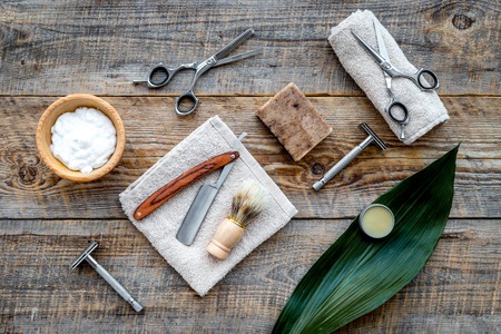 Barber workplace. Shaving brush, razor, foam on wooden table background top view.の写真素材