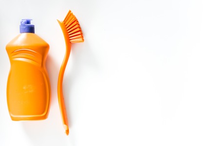 Dishwashing liquid, brushes and tableware on white background top view.の写真素材