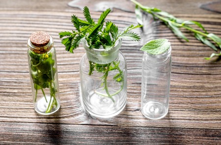 Homeopathy. Store up medicinal herbs. Herbs in glass on wooden table background.の写真素材