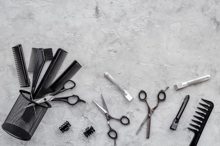 Hairdresser workplace. Combs and sciccors on grey table background top view.の写真素材