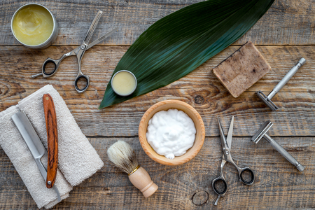 Barber workplace. Shaving brush, razor, foam on wooden table background top view.の写真素材